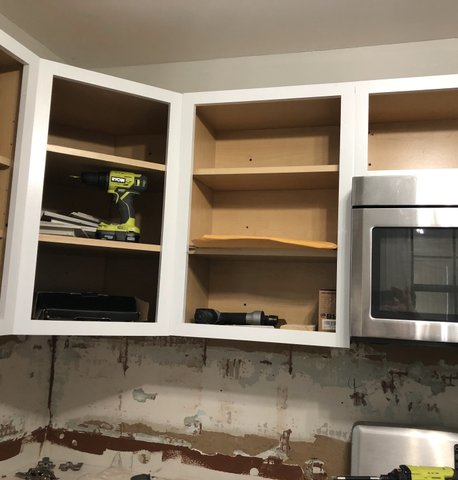 Kitchen cabinets being painted — spray application in progress