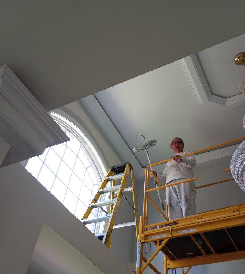 Romero painting a grand foyer ceiling on scaffolding in New Jersey